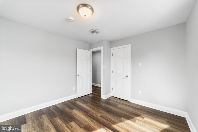 unfurnished bedroom featuring dark hardwood / wood-style flooring