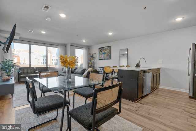 dining space featuring light hardwood / wood-style floors and sink