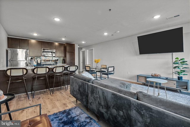 living room with light hardwood / wood-style flooring and sink