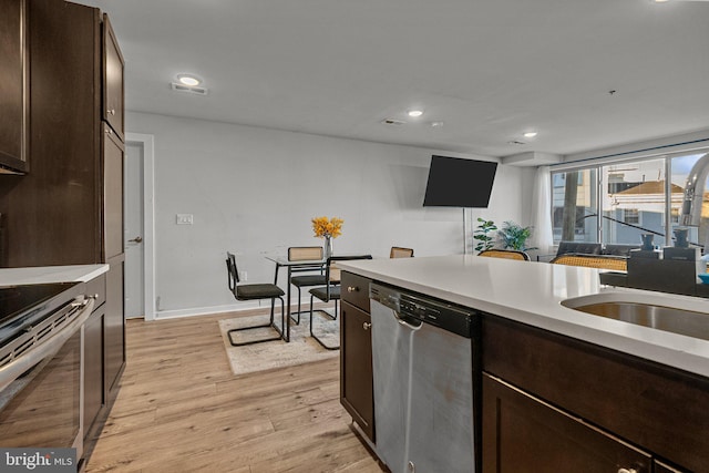 kitchen with dark brown cabinets, light wood-type flooring, sink, and appliances with stainless steel finishes