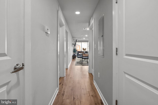 hallway with light wood-type flooring and electric panel