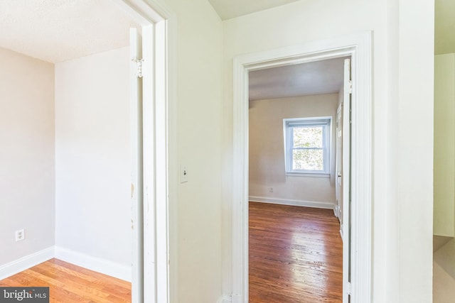 hallway featuring hardwood / wood-style floors and a textured ceiling