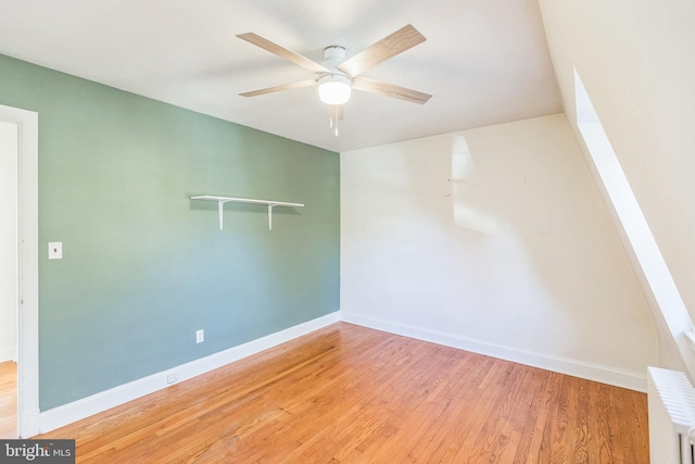 spare room with radiator heating unit, wood-type flooring, and ceiling fan