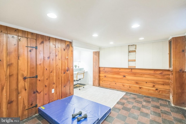 workout room featuring wooden walls and crown molding