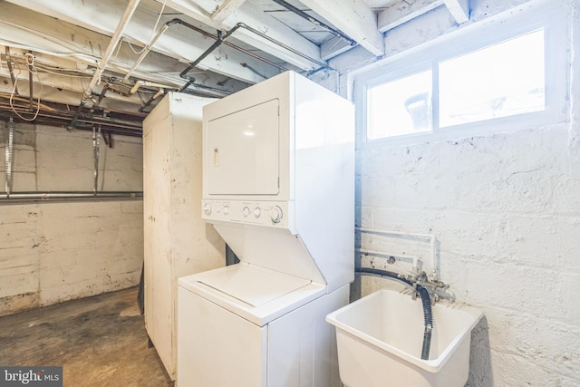 washroom with stacked washer / dryer and sink