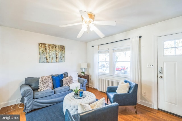 living room featuring radiator, ceiling fan, hardwood / wood-style floors, and a healthy amount of sunlight