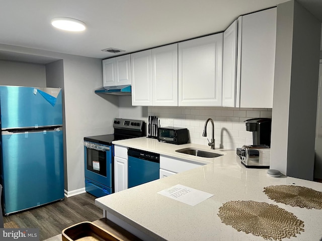 kitchen with sink, dark hardwood / wood-style floors, backsplash, white cabinets, and appliances with stainless steel finishes