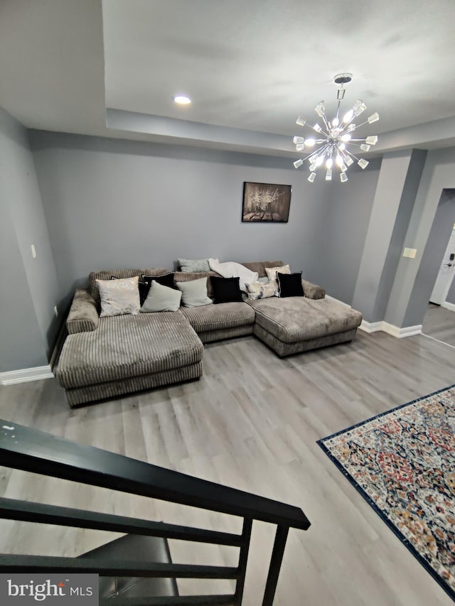 living room featuring wood-type flooring and an inviting chandelier