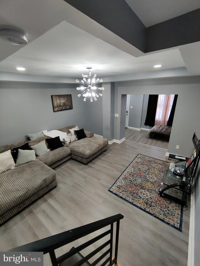 living room with light hardwood / wood-style floors and a chandelier