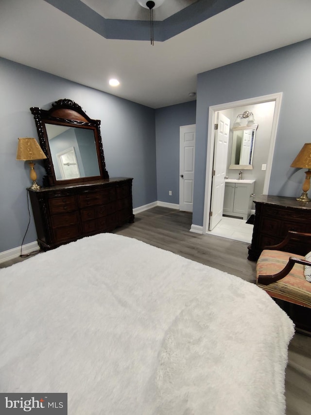 bedroom featuring wood-type flooring, ceiling fan, and connected bathroom