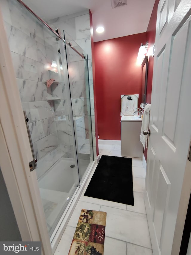 bathroom featuring tile patterned flooring, vanity, and a shower with door