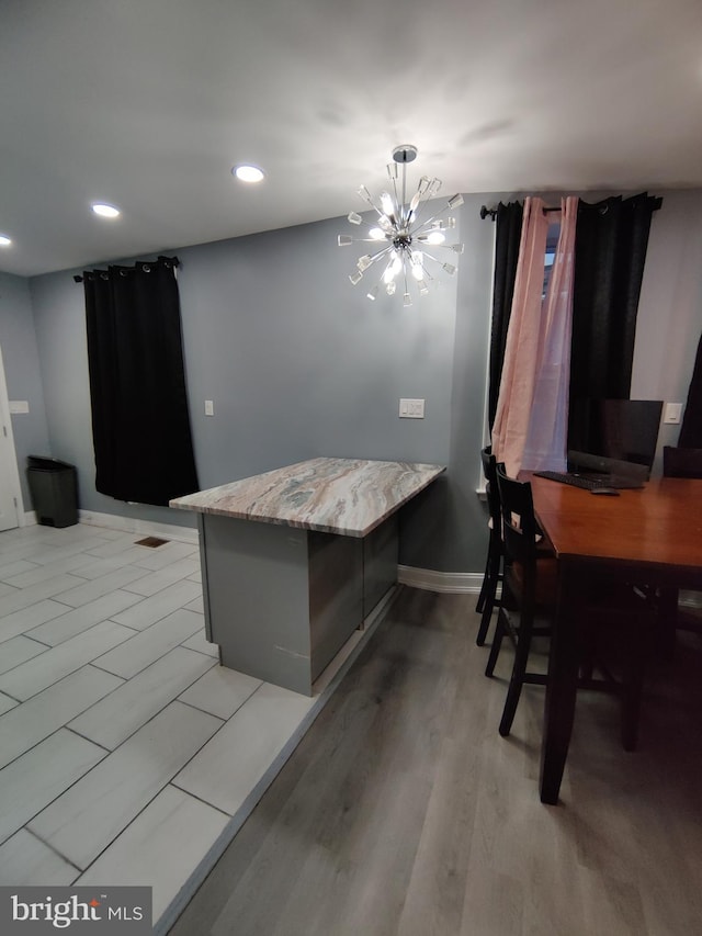 dining area with light hardwood / wood-style floors and a chandelier