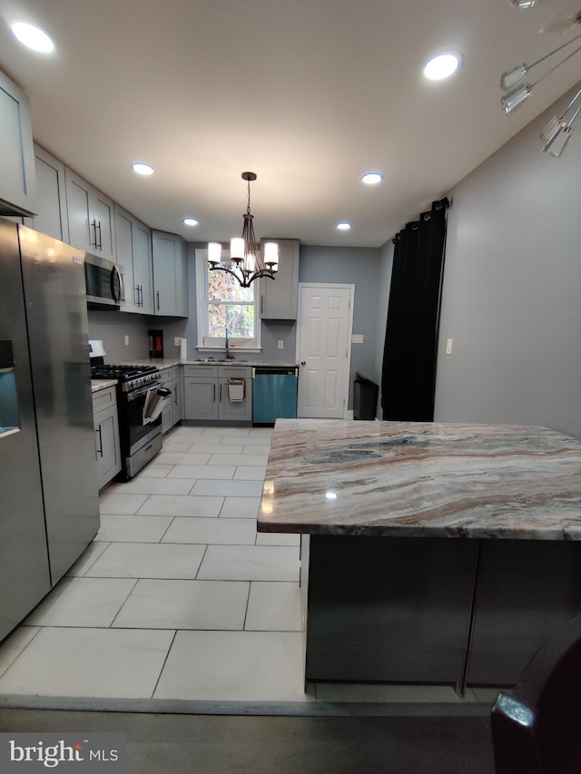 kitchen with a chandelier, sink, gray cabinetry, appliances with stainless steel finishes, and decorative light fixtures