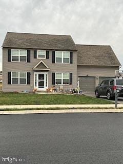 view of front of property with a front yard and a garage