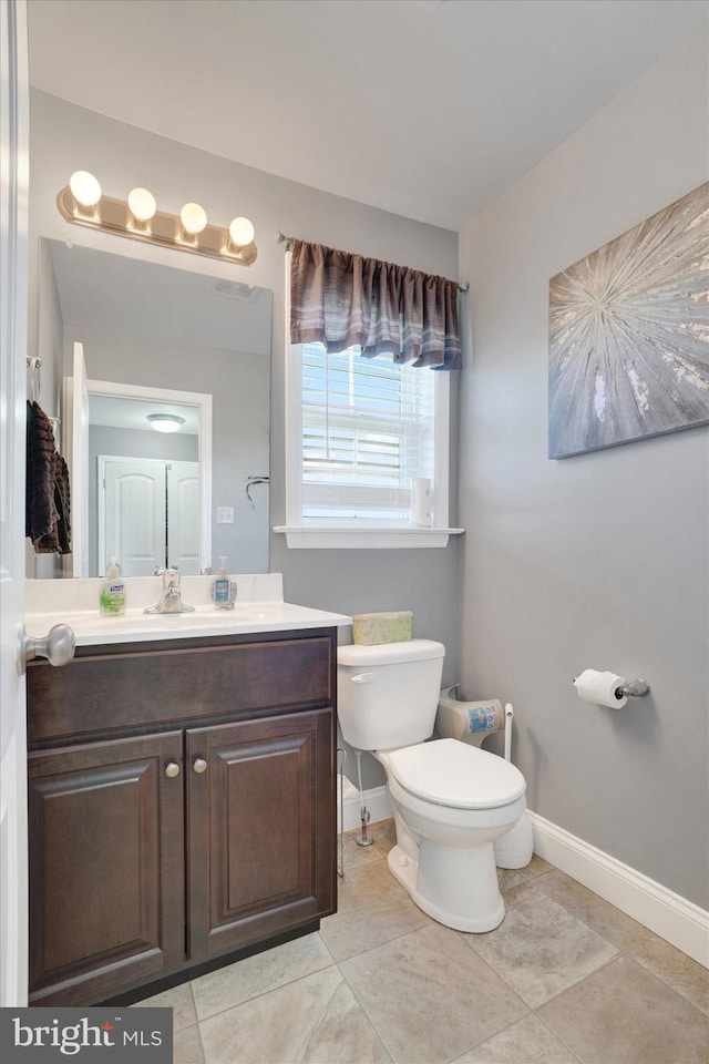 bathroom with vanity, toilet, and tile patterned floors