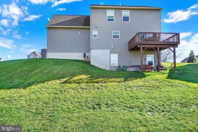 rear view of property featuring a yard and a deck