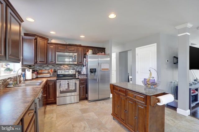 kitchen with decorative backsplash, sink, a center island, and stainless steel appliances