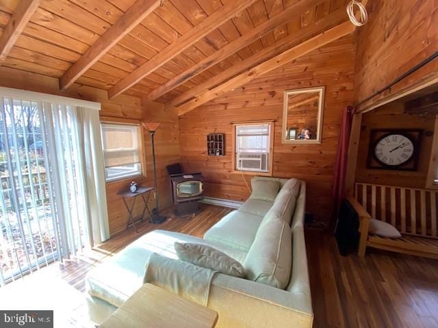 sitting room with wood walls, hardwood / wood-style flooring, wooden ceiling, a wood stove, and lofted ceiling with beams