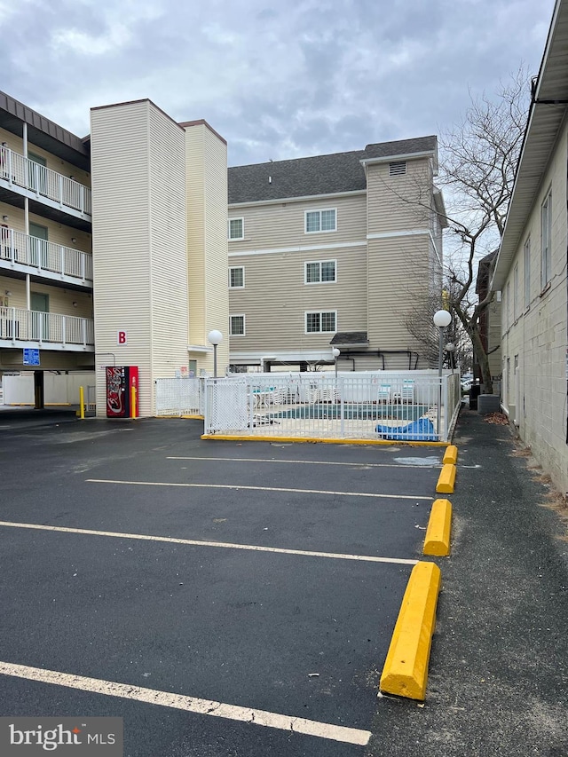 view of car parking featuring a swimming pool