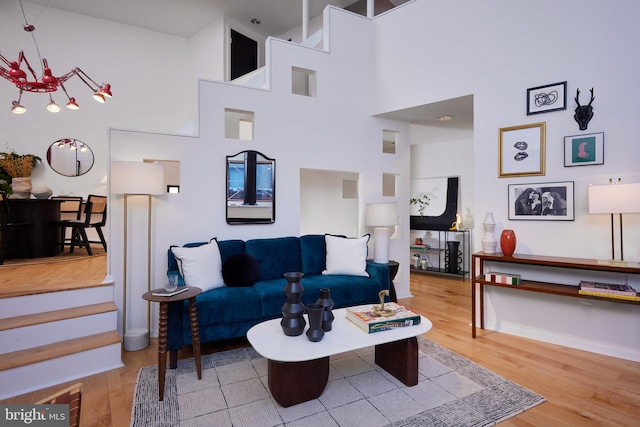 living room with hardwood / wood-style floors and a towering ceiling