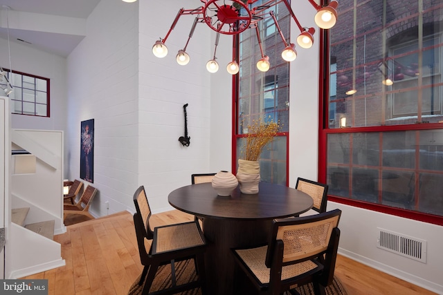 dining area featuring hardwood / wood-style floors and a high ceiling