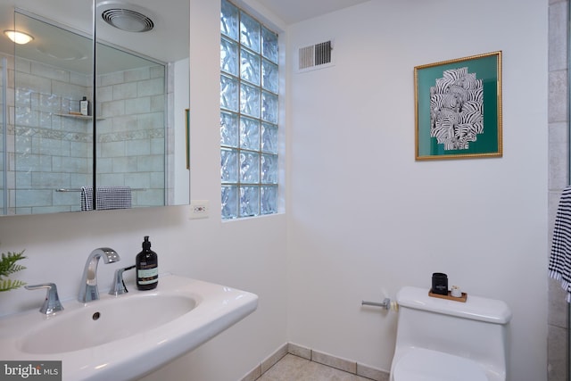 bathroom featuring tile patterned flooring, toilet, and sink