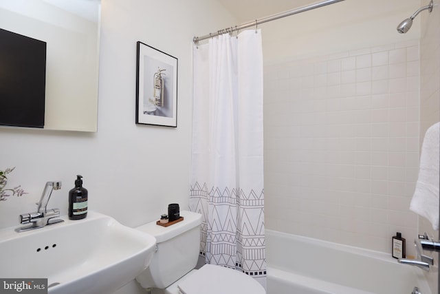 full bathroom featuring shower / bath combination with curtain, toilet, and sink