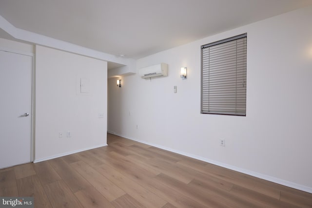 unfurnished room featuring light hardwood / wood-style floors and a wall mounted AC