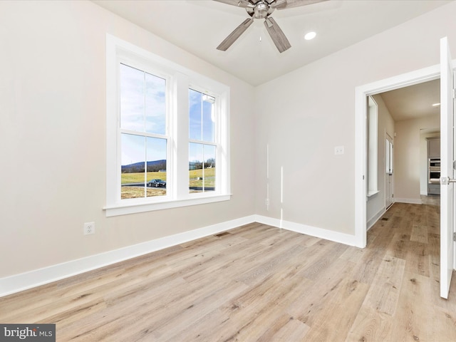 spare room with light hardwood / wood-style floors and ceiling fan