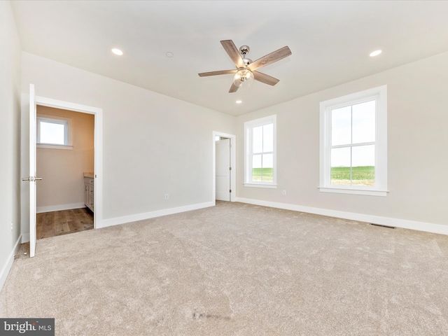 unfurnished room featuring light carpet and ceiling fan