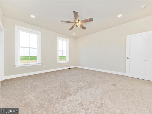 empty room featuring light colored carpet and ceiling fan