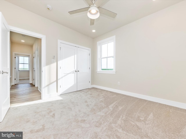 unfurnished bedroom with ceiling fan, light colored carpet, and multiple windows