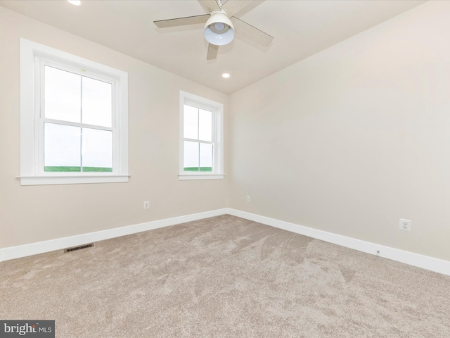 spare room featuring light carpet and ceiling fan