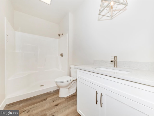 bathroom featuring a shower, toilet, vanity, and hardwood / wood-style flooring