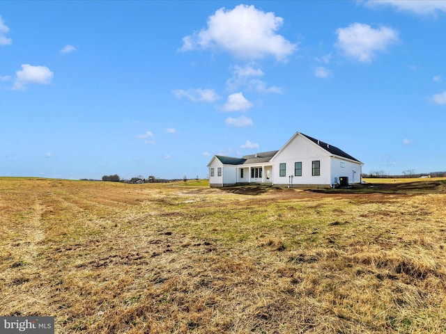 exterior space with a rural view and a front yard