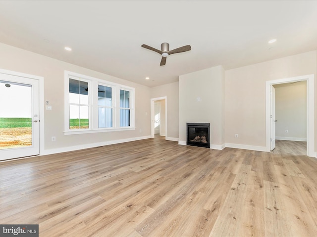 unfurnished living room with ceiling fan and light hardwood / wood-style flooring