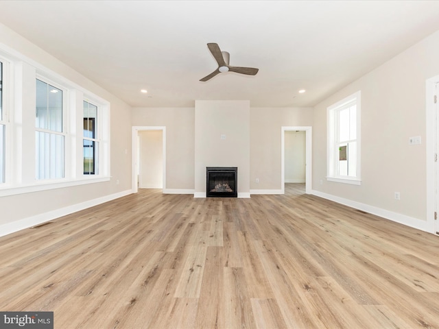 unfurnished living room featuring light hardwood / wood-style floors, ceiling fan, and a healthy amount of sunlight