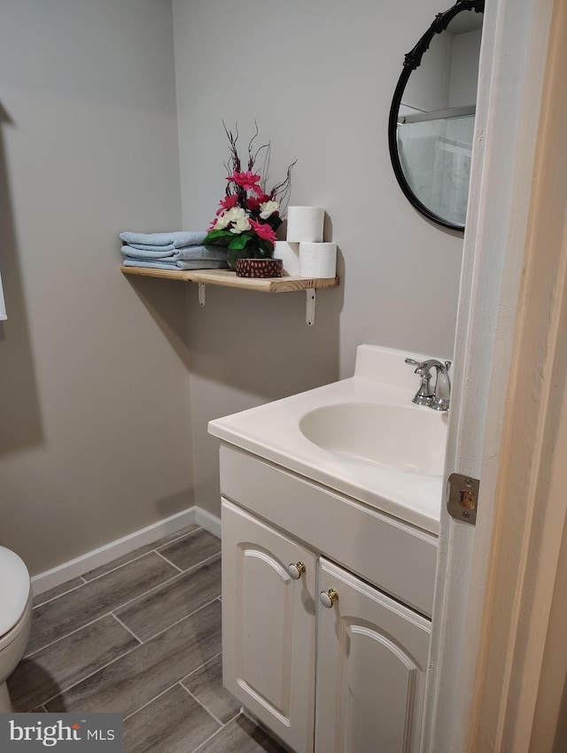 465 Baltimore Ave, Cumberland, MD 21502 - bathroom featuring wood finish floors, vanity, baseboards, and toilet