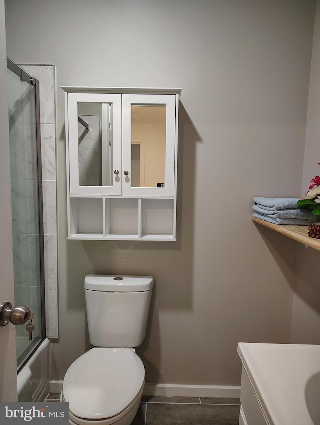 full bathroom with bath / shower combo with glass door, vanity, and toilet