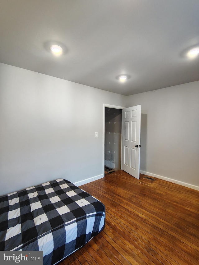 unfurnished bedroom with dark hardwood / wood-style flooring