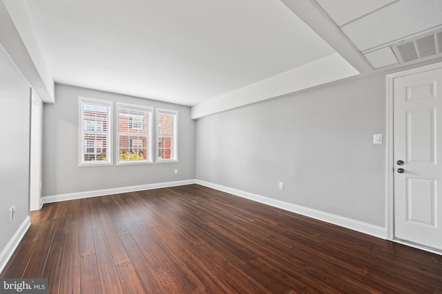 unfurnished room with hardwood / wood-style flooring and a drop ceiling