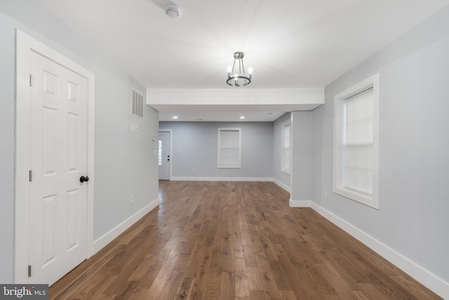 spare room featuring a notable chandelier and dark hardwood / wood-style floors