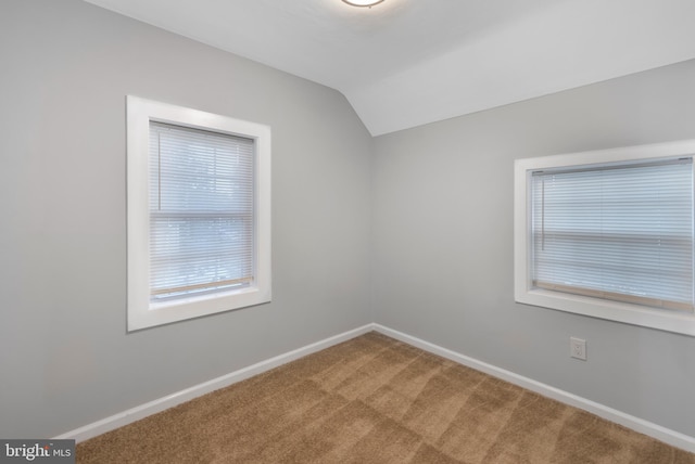 empty room with vaulted ceiling and carpet