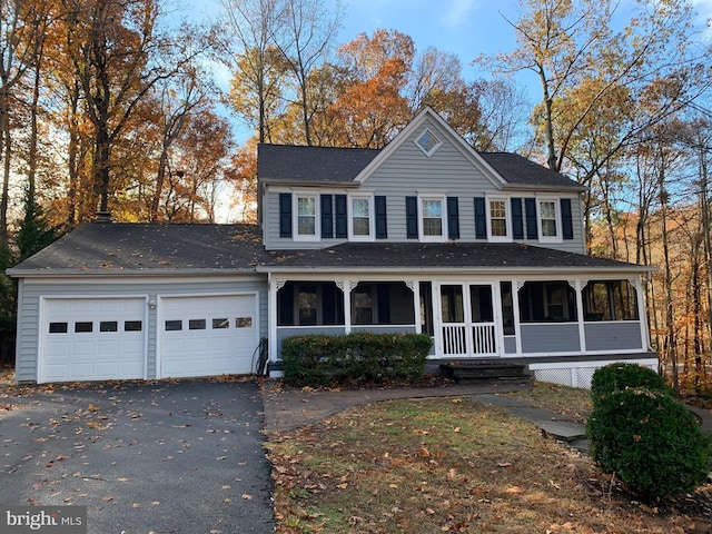 view of front of home with aphalt driveway, covered porch, a garage, and a shingled roof