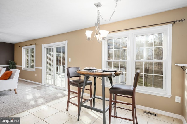 dining space with a chandelier, visible vents, light carpet, and baseboards