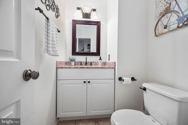 bathroom featuring vanity, tile patterned floors, and toilet