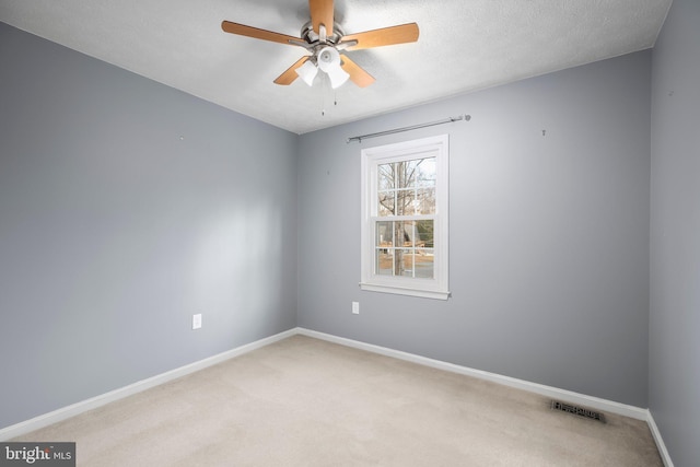 unfurnished room featuring a ceiling fan, baseboards, visible vents, a textured ceiling, and light carpet