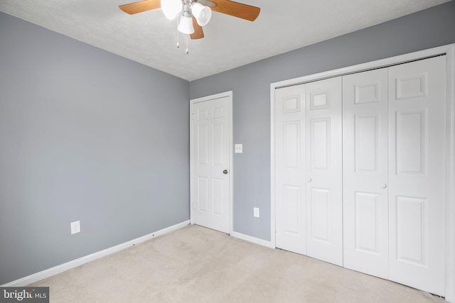 unfurnished bedroom featuring baseboards, carpet floors, a closet, and ceiling fan