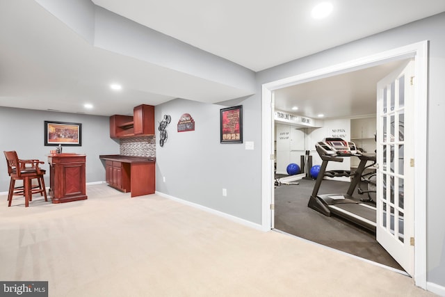 workout room with recessed lighting, baseboards, light carpet, and a dry bar