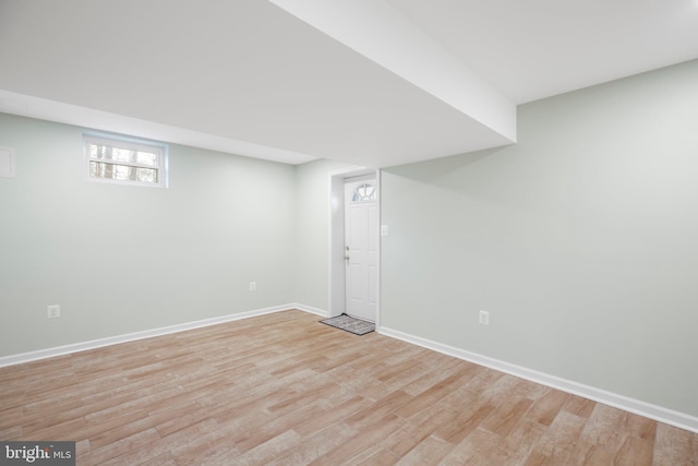 below grade area with baseboards and light wood finished floors